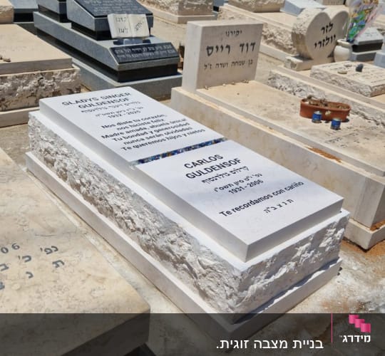 מצבות אבן עם כיתוב בעברית ובאנגלית בבית קברות